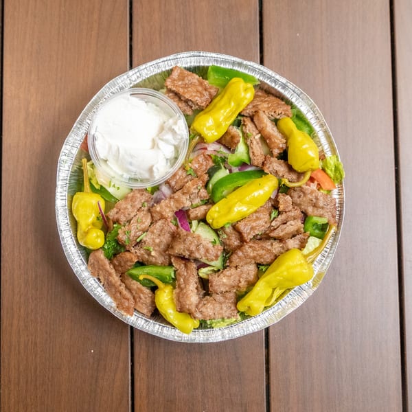 Liberty's Mediterranean Giant Grinders' gyro salad with meat, peppers, and a side of tzatziki sauce.